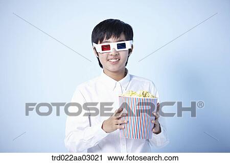 a boy watching a 3d movie with popcorn View Large Photo Image Stock Image - a boy watching a 3d movie with popcorn. Fotosearch