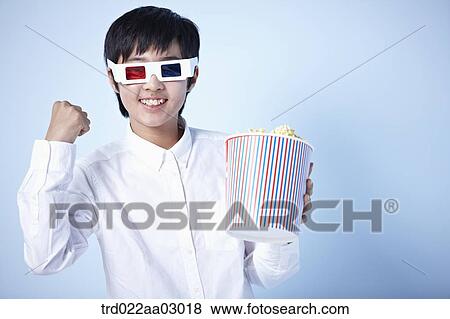 a boy watching a 3d movie with popcorn View Large Photo Image Stock Photo - a boy watching a 3d movie with popcorn. Fotosearch