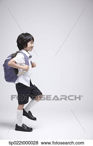 a boy wearing a school bag walking in white background View Large Photo Image Stock Photo - a boy wearing a school bag walking in white background. Fotosearch