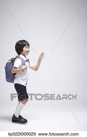 Stock Photo - a boy wearing a school bag walking in white background. Fotosearch