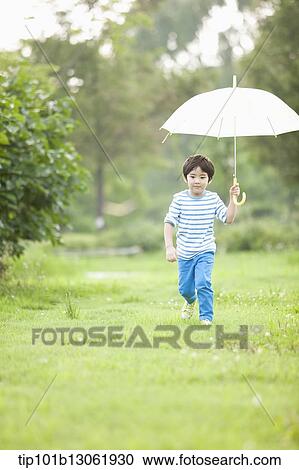 Stock Image - a boy with an umbrella. Fotosearch