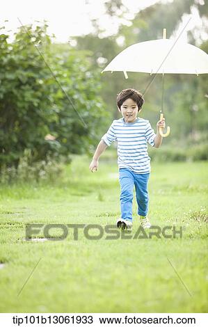 Stock Image - a boy with an umbrella. Fotosearch