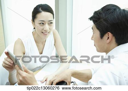 Stock Photograph - a business man and a business woman at a coffee shop. Fotosearch