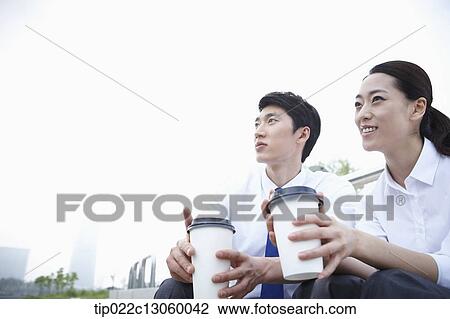 Stock Image - a business man and a business woman next to a river. Fotosearch