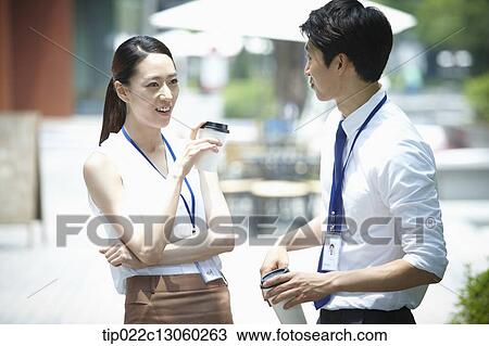 Stock Image - a business man and a business woman talking to each other. Fotosearch