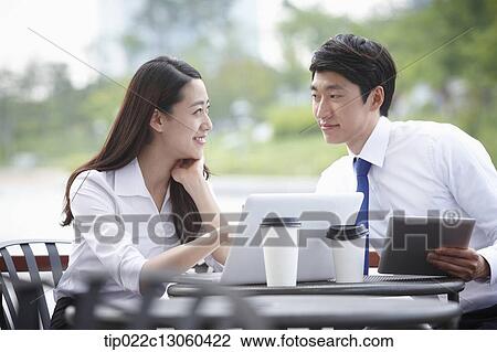 Stock Image - a business man and a business woman talking to each other. Fotosearch
