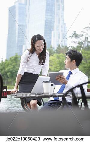 Stock Image - a business man and a business woman talking to each other. Fotosearch