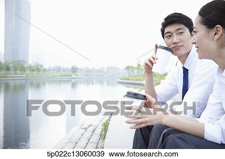 Stock Photo - a business man and a business woman next to a river. Fotosearch
