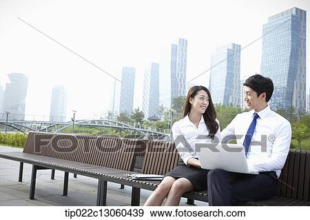 Stock Photo - a business man and a business woman working together. Fotosearch