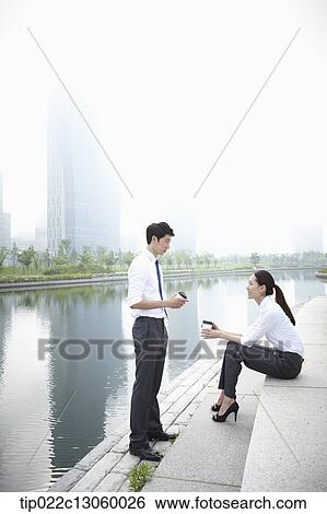 Stock Photograph - a business man and a business woman next to a river. Fotosearch