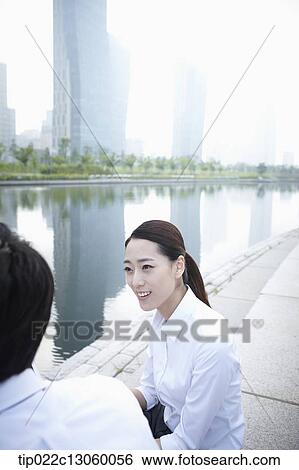 Stock Photograph - a business man and a business woman next to a river. Fotosearch