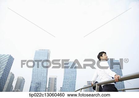 a business man leaning on a fence View Large Photo Image Stock Image - a business man leaning on a fence. Fotosearch