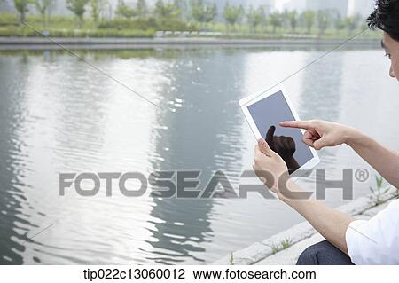 a business man sitting next to a river View Large Photo Image Stock Image - a business man sitting next to a river. Fotosearch