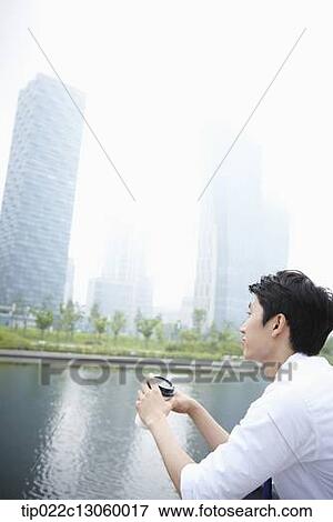 Stock Photo - a business man sitting next to a river. Fotosearch