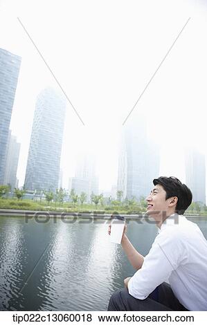 Stock Photo - a business man sitting next to a river. Fotosearch
