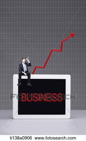 Stock Photograph - a business man sitting on a tablet with the word business. Fotosearch