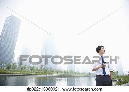 a business man standing next to a river View Large Photo Image Stock Image - a business man standing next to a river. Fotosearch