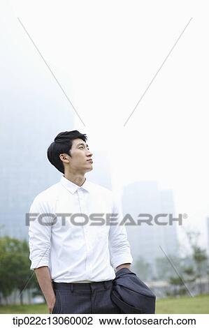 a business man standing with a city in the background View Large Photo Image Stock Image - a business man standing with a city in the background. Fotosearch