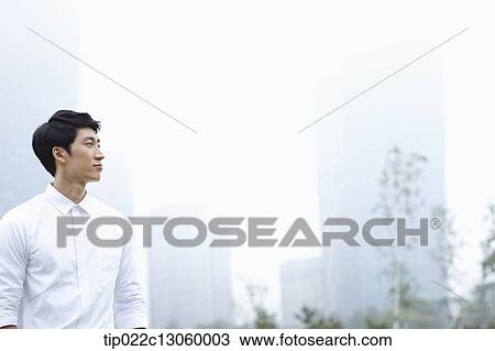 a business man standing with a city in the background View Large Photo Image Stock Image - a business man standing with a city in the background. Fotosearch
