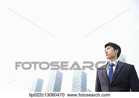 Stock Image - a business man with skyscrapers in the back. Fotosearch