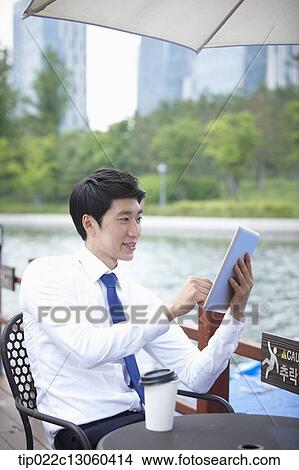 Picture - a business man working with a tablet. Fotosearch