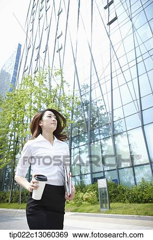 Stock Photo - a business woman running with a coffee. Fotosearch
