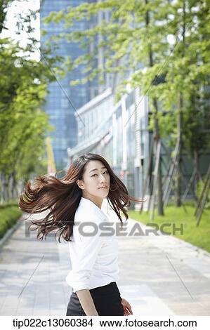 Picture - a business woman walking on the street. Fotosearch