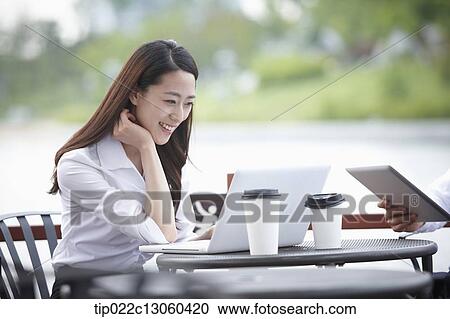 a business woman working while having a coffee View Large Photo Image Stock Image - a business woman working while having a coffee . Fotosearch