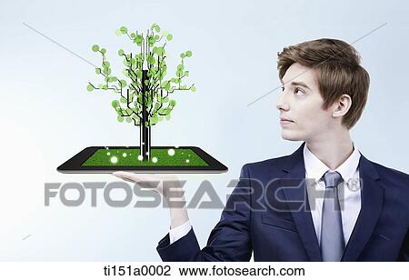a businessman holding a tablet PC with a tree View Large Photo Image Stock Image - a businessman holding a tablet PC with a tree. Fotosearch