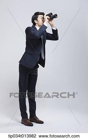 Stock Image - a businessman looking at something with binocular. Fotosearch