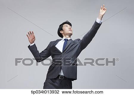 Stock Image - a businessman trying to reach something. Fotosearch