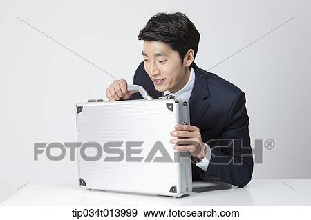Stock Photo - a businessman with a business bag on a table. Fotosearch