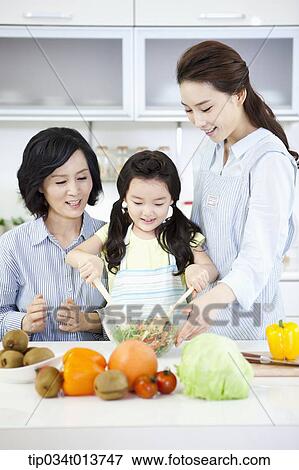 Stock Photo - a child cooking with two women in the kitchen. Fotosearch