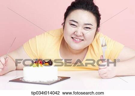 a chubby woman with a cake in front of her View Large Photo Image Stock Image - a chubby woman with a cake in front of her. Fotosearch