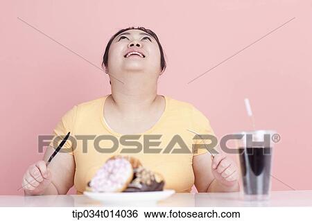 Stock Photograph - a chubby woman with a plate of doughnuts. Fotosearch