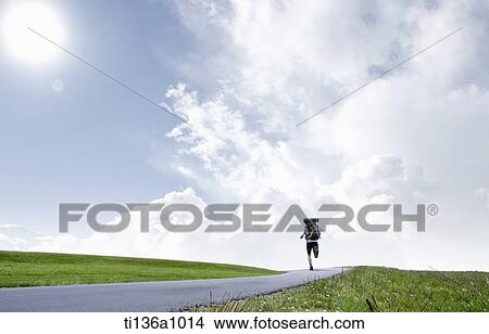 Picture - a couple hiking on a grass field. Fotosearch