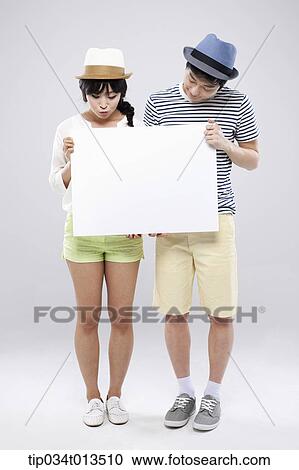 Stock Image - a couple holding an empty board together. Fotosearch
