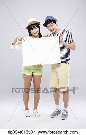 Stock Photo - a couple holding an empty board together. Fotosearch
