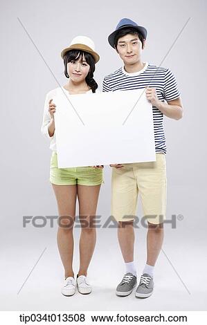 Stock Photo - a couple holding an empty board together. Fotosearch