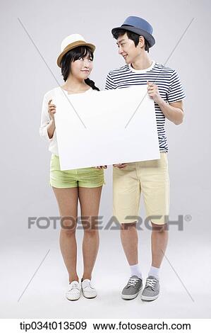 Stock Photo - a couple holding an empty board together. Fotosearch