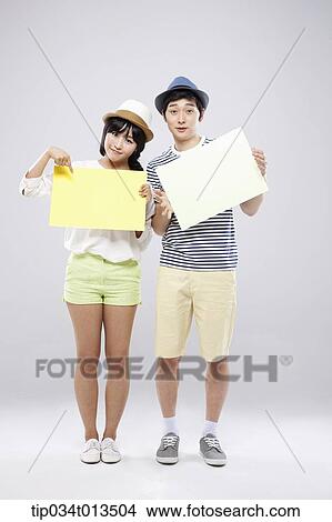 Picture - a couple holding empty boards . Fotosearch