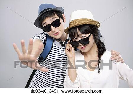 Stock Image - a couple with sunglasses posing together. Fotosearch