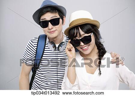 Stock Image - a couple with sunglasses posing together. Fotosearch