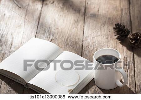 a cup of coffee next to a book on wooden surface View Large Photo Image Stock Photography - a cup of coffee next to a book on wooden surface. Fotosearch