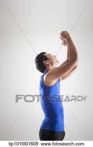 Stock Photo - a fit man in blue shirt posing with hands. Fotosearch