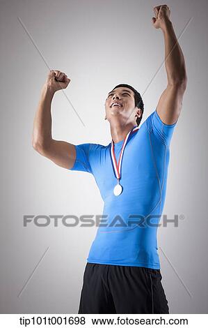 a fit man in blue shirt posing with gold medal around his neck View Large Photo Image Stock Photo - a fit man in blue shirt posing with gold medal around his neck. Fotosearch