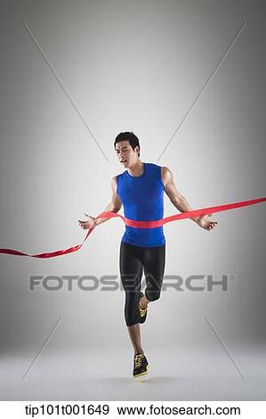 Stock Photo - a fit man in blue shirt running to a finishing line. Fotosearch