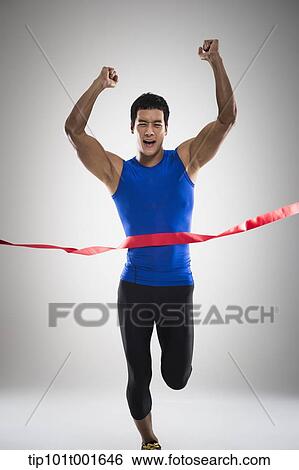 Stock Photograph - a fit man in blue shirt running to a finishing line. Fotosearch
