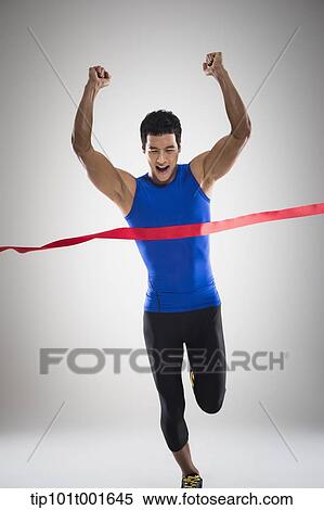 Stock Photography - a fit man in blue shirt running to a finishing line. Fotosearch