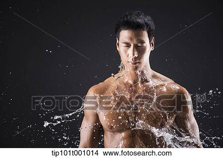 a fit man posing in black background with water splash View Large Photo Image Picture - a fit man posing in black background with water splash. Fotosearch